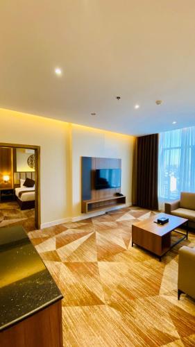 a large living room with a couch and a tv at Sakura City Hotel in Al Baha