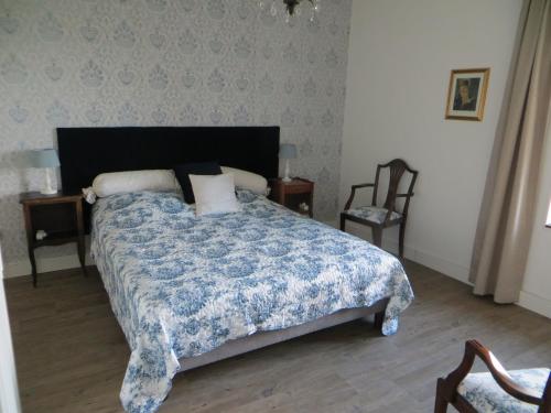 a bedroom with a bed with a blue comforter at Les Meules in Saint-Basile