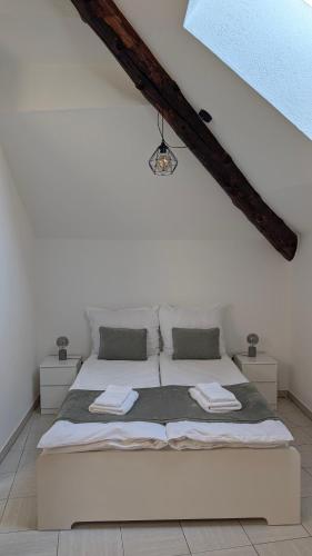 a bedroom with a white bed with two pillows at Ascona, Casa Collegio - im Zentrum, am See Lago Maggiore in Ascona