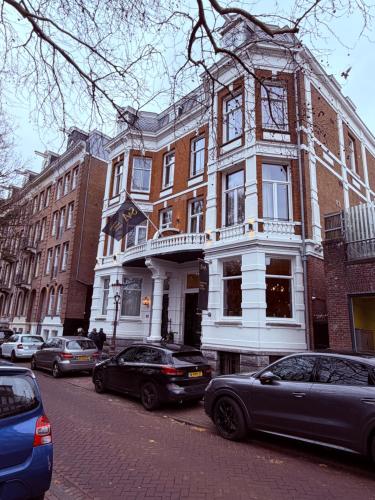 a building on a city street with cars parked in front at S&A Vondel Park Hotel in Amsterdam