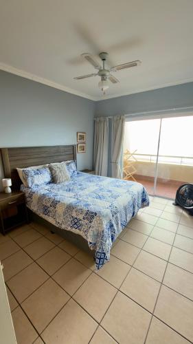 a bedroom with a bed and a ceiling fan at L’Escalier Cabanas 510 in Amanzimtoti
