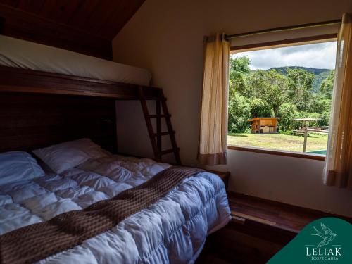 a bedroom with a bed and a window with a view at Hospedaria Leliak - Retiro Boutique de Montanha in Aiuruoca