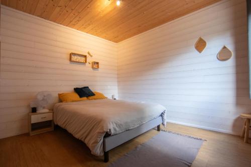a bedroom with a bed and a wooden wall at Eco-lodges Lacanau Moutchic Inn - 4 pers in Lacanau