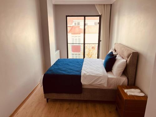 a small bedroom with a bed with a window at Bediroğlu Airport Apart in Arnavutköy