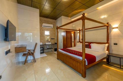 a bedroom with a canopy bed and a desk at W&H View Residency in Cochin