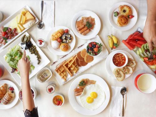 un tavolo di cibo con piatti di cibo di Novotel Samator Surabaya Timur a Surabaya
