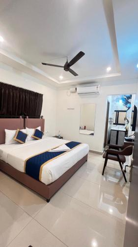 a bedroom with a bed with a ceiling fan and a chair at Bakthapriya HILL VIEW RESIDENCY in Srikalahasti