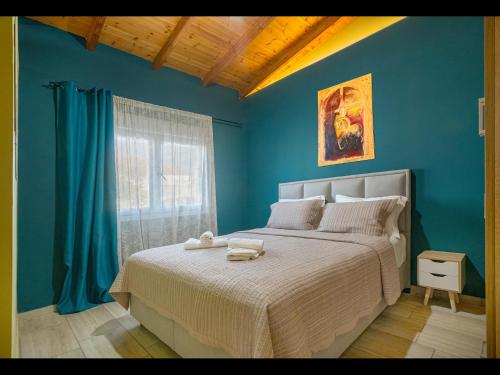 a bedroom with a large bed with blue walls at Hara Apartments in Chrysoupolis
