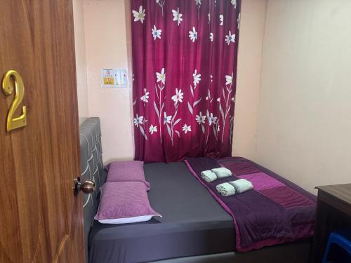 a small bed in a room with a red curtain at ff HILLTOP VIEW in Kampong Kundassan