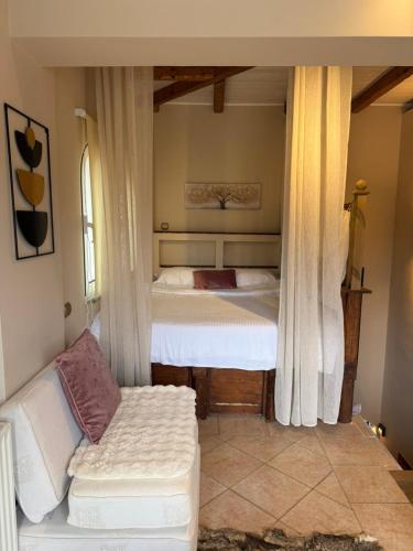 a bedroom with a bed and a couch in a room at Κτήμα Παππά Ρετιρέ in Livadeia