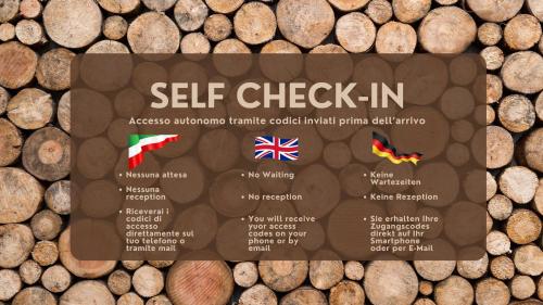 a sign for a self check in on a pile of logs at Le Vette in Rovereto