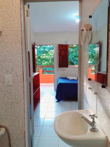 a bathroom with a sink and a room with a bed at Pousada Rota Beach in Porto De Galinhas