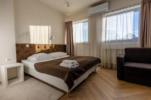 ein Hotelzimmer mit einem Bett und einem Stuhl in der Unterkunft Hotel Wena in Breslau