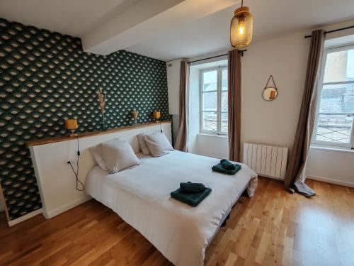 a bedroom with a white bed with two towels on it at Petit appartement centre historique Laval in Laval