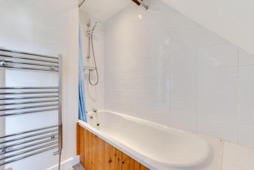 a white bathroom with a tub and a shower at 3 Bed in Whitby oc-w009 in Whitby
