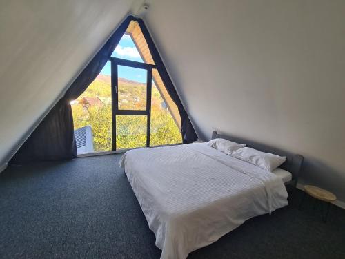 a bedroom with a bed and a large window at The House in Corbi