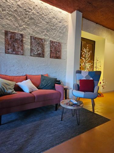 a living room with a couch and a chair at Dolcevita guest house in Torreano