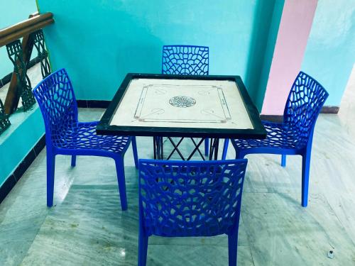 een tafel met drie stoelen en een tafel met een tafel bij Butterfly Blossom Villa in Samayapuram