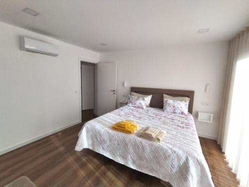 a bedroom with a bed with two towels on it at Casa de Santa Luzia in Vila Praia de Âncora