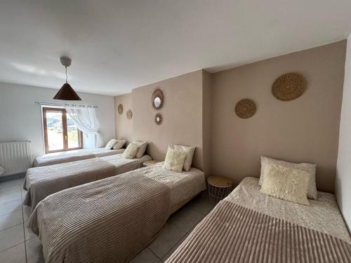 a group of four beds in a room at Gîte Baytso in Auge