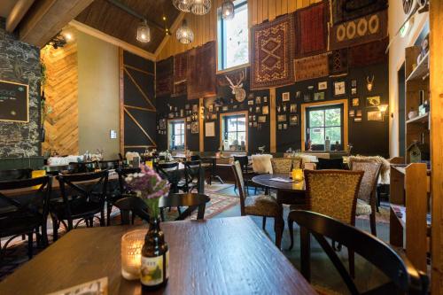 un ristorante con tavoli e sedie in una stanza di Unieke Yurt in het bos met jacuzzi en sauna a Erp