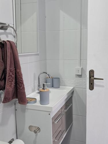 a white bathroom with a sink and a mirror at Oásis Xangri-lá in Xangri-lá
