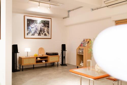 a living room with a table and a picture on the wall at Shibuya Beatles house 10min walk from Shibuya Station in Tokyo