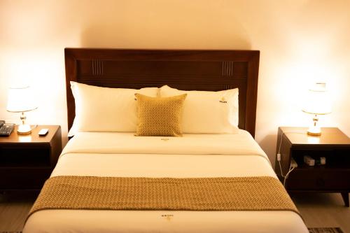 a bedroom with a large bed with two night stands at Tales Luxury in Kampala