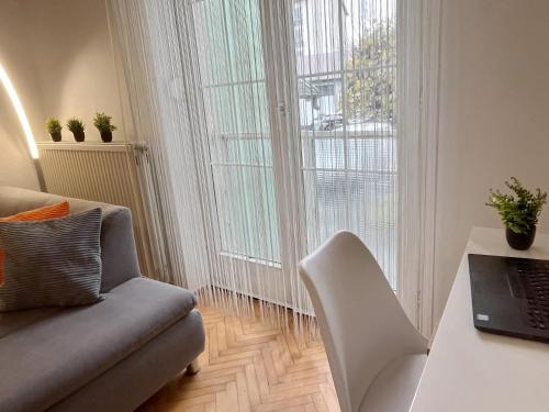 a living room with a couch and a table with a laptop at Home4You Szombathely in Szombathely