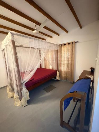a bedroom with a bed with a mosquito net at Surf Forever in Midigama East