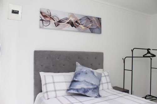 a bedroom with a bed with a blue and white pillow at Tash's Place in Roodepoort