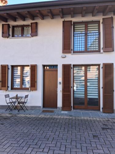 a house with wooden doors and a patio at Luce in Grassobbio