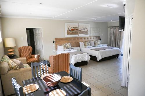 a bedroom with a bed and a living room at Matts Rest Bnb & Self-catering in Pietermaritzburg