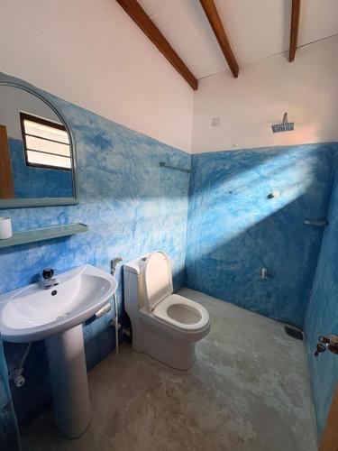 a bathroom with a white toilet and a sink at Surf Forever in Midigama East