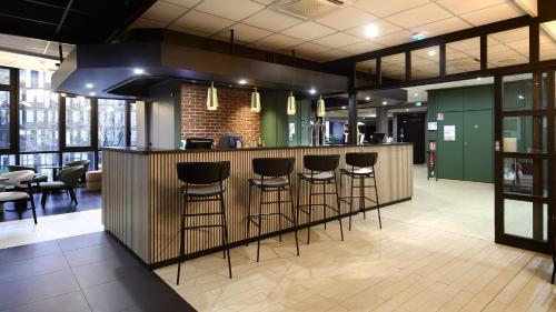 a bar with bar stools in a restaurant at Campanile PRIME - Arcueil in Arcueil