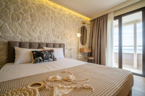 een slaapkamer met een groot bed met een groot raam bij Aurora Suites, By IdealStay Experience in Amoudara Herakliou