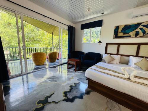a bedroom with a bed and a balcony at River Splendour Home Stay in Ella