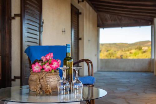 een tafel met een fles wijn en een mand met bloemen bij Evia Escape in Vathírrevma