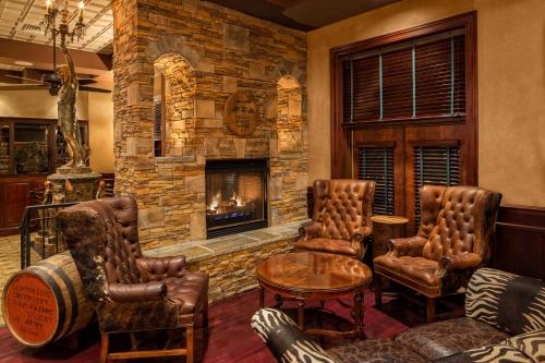 a living room with leather furniture and a stone fireplace at Carnegie Hotel & Spa in Johnson City