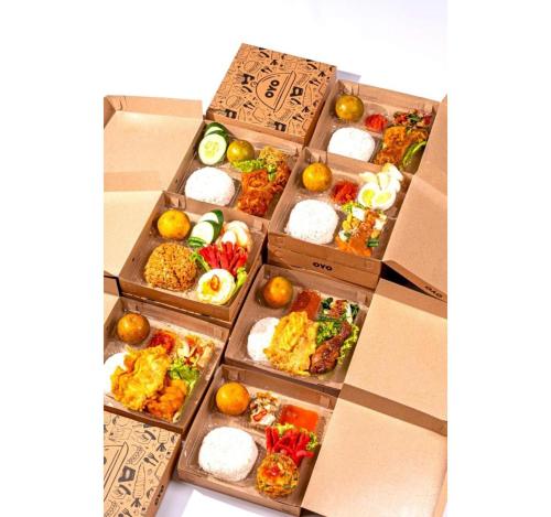 een stapel dozen gevuld met verschillende soorten voedsel bij Collection O 3431 Hotel Alpha Bandara in Palembang