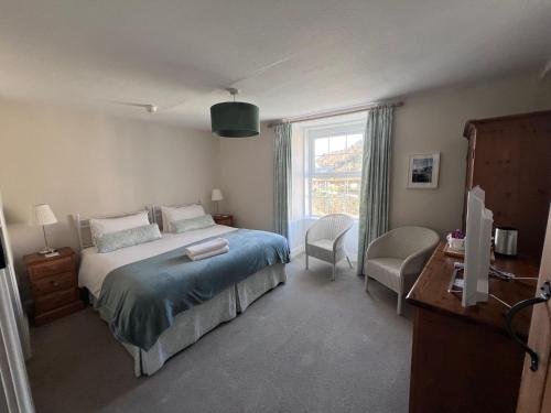 een slaapkamer met een bed en een raam bij Bay View Guest House in Beer