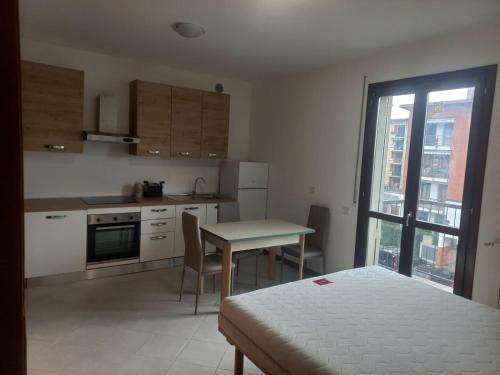 een keuken met een bed, een tafel en een raam bij Residenza Caniana in Torre Boldone