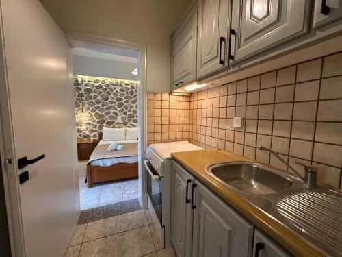a kitchen with a sink and a bed in a room at Alkionis Garden View Apartments in Lefkada