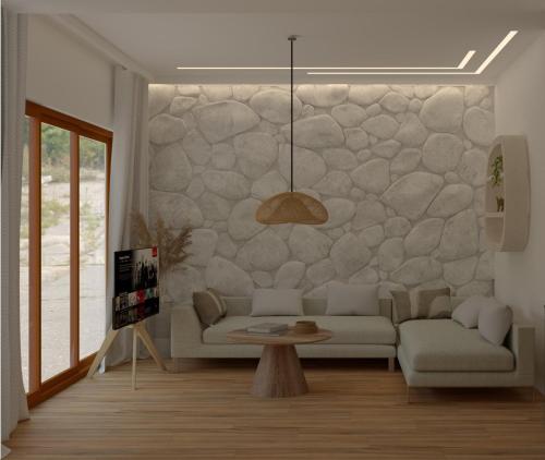 een woonkamer met een bank en een stenen muur bij Aurora Suites, By IdealStay Experience in Amoudara Herakliou