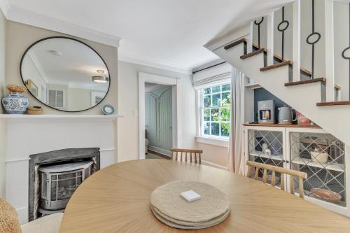 a dining room with a table and a fireplace at Newly Renovated Carriage House in Hillsborough