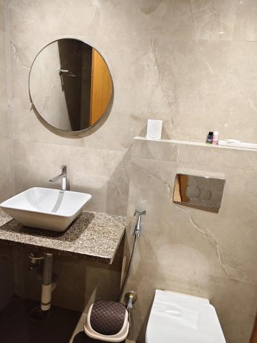 a bathroom with a sink and a mirror at Hashtag Inn opposite Sarusajai Stadium in Guwahati