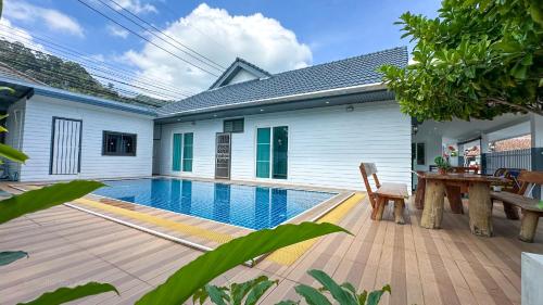 a house with a swimming pool and a wooden deck at Soulful Stay Phuket -Distant Seaview and Mountain View Retreat, Patong in Patong Beach