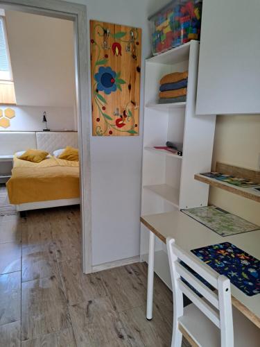 een kamer met een bureau en een bed bij Dolina Miodu - Kaszuby, Sauna, Gorąca Balia in Borowina