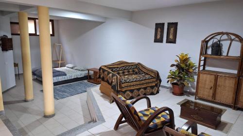 ein Wohnzimmer mit einem Bett und einem Tisch in der Unterkunft Kaza Manata in Praia