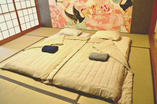 a large bed in a room with a wall at つるふく in Misaki
